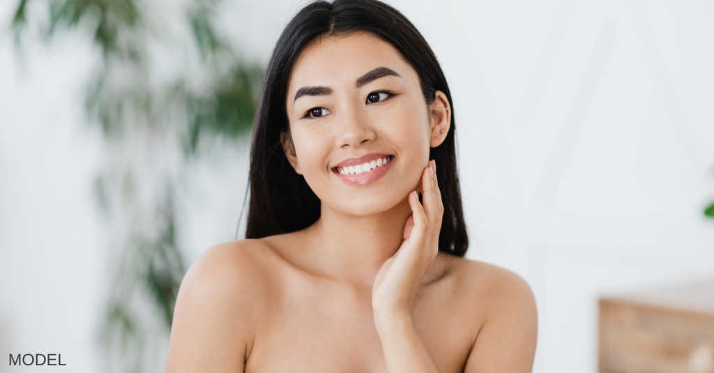 Woman touching her face and smiling (model)