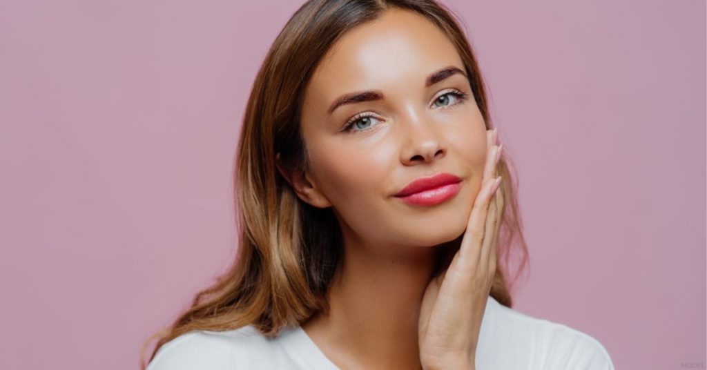 A woman posing with her hands on her face (model)