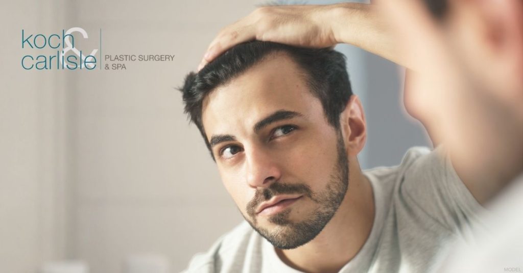 Man examining his hair. (Model) Koch & Carlisle Plastic Surgery & Spa Logo